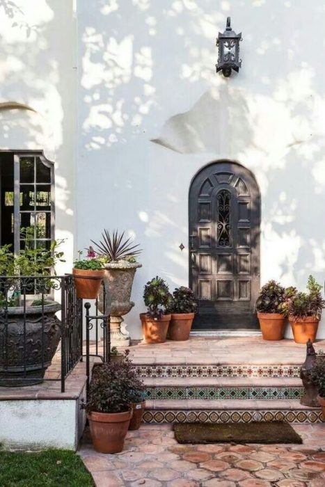 Home entrance in Spanish style with flower pots